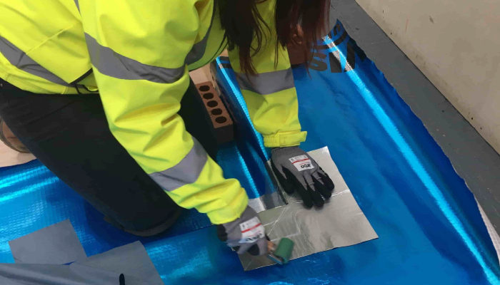 lap tape being applied to visqueen gas barrier